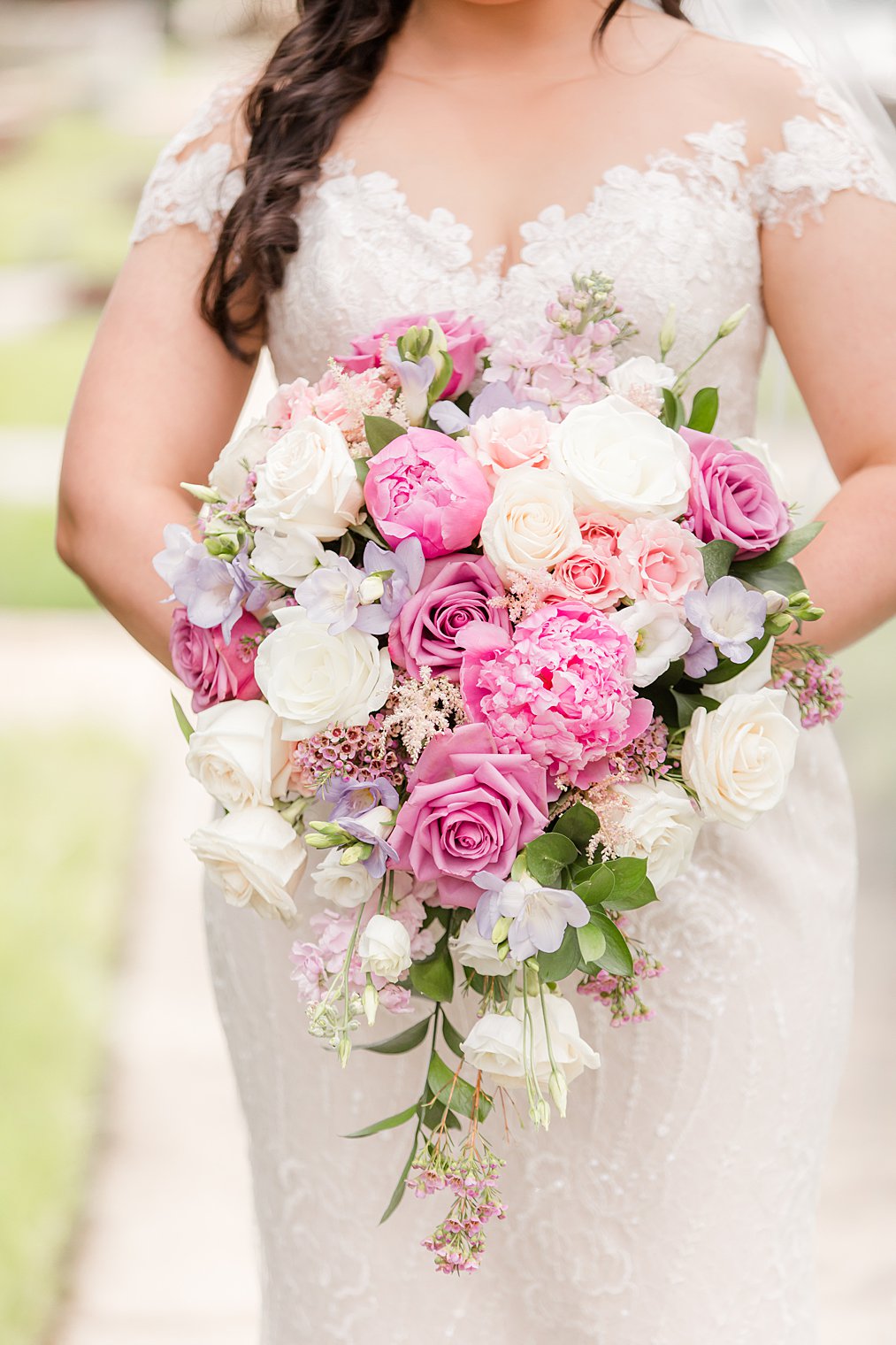 bride holds bouquet with bright pink and ivory florals 