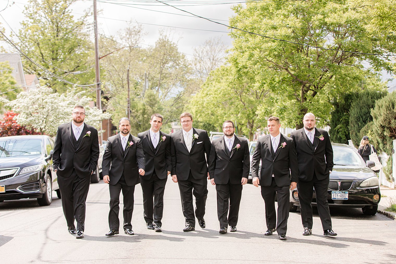 groom walks with groomsmen before Staten Island wedding