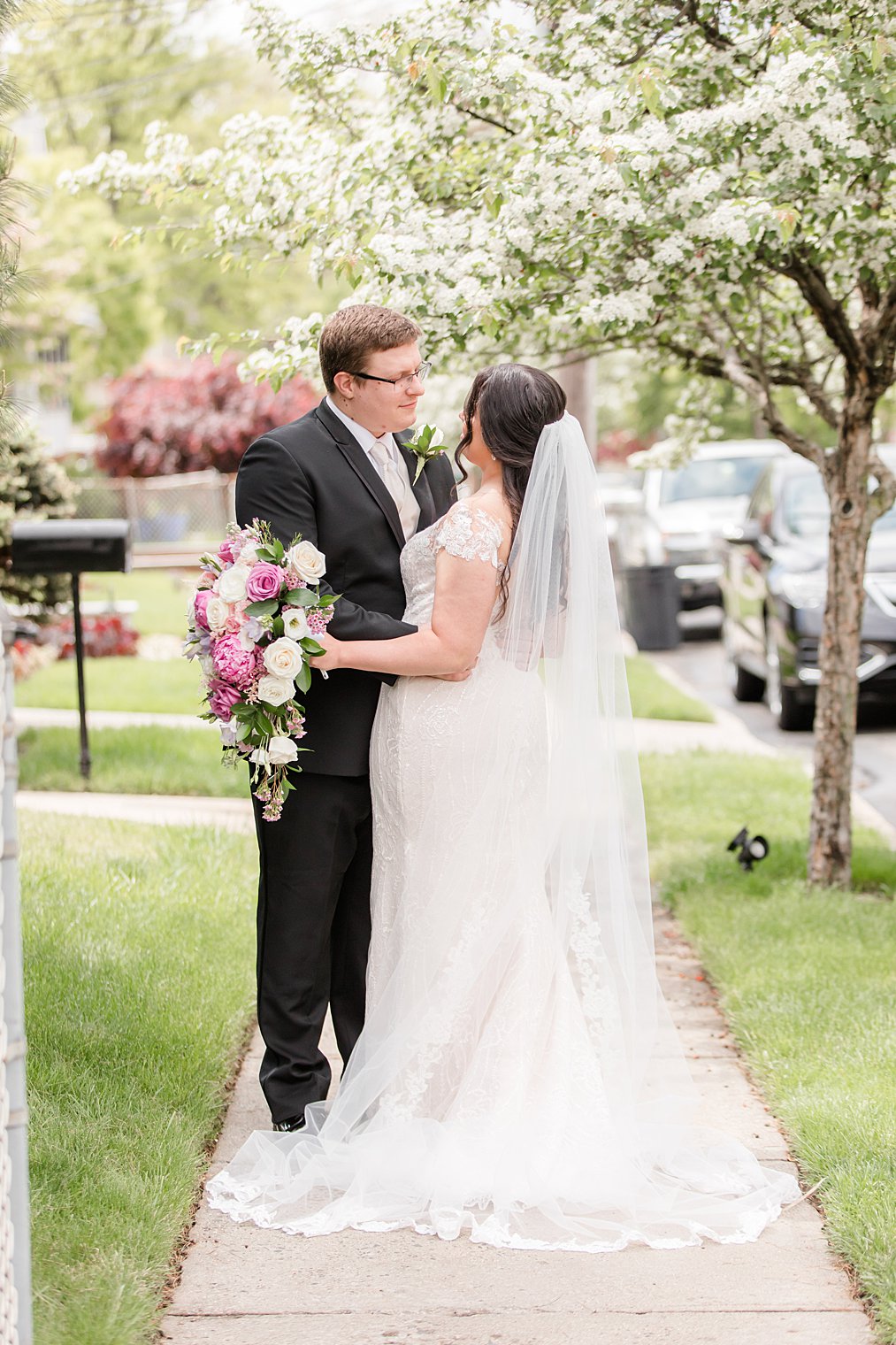 bride and groom pose on sidewalk in Staten Island neighborhood 
