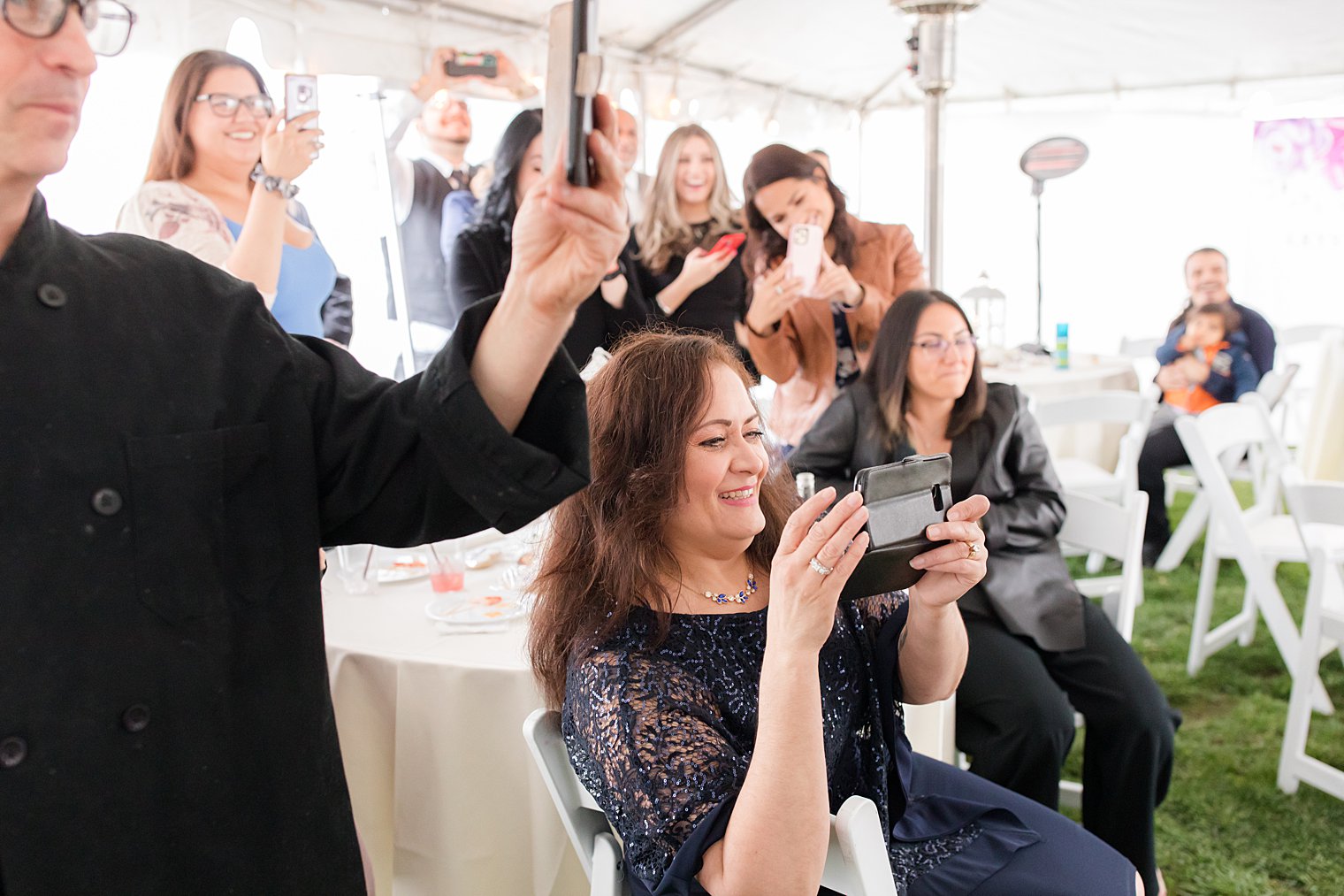 family takes photos of wedding ceremony with phones 