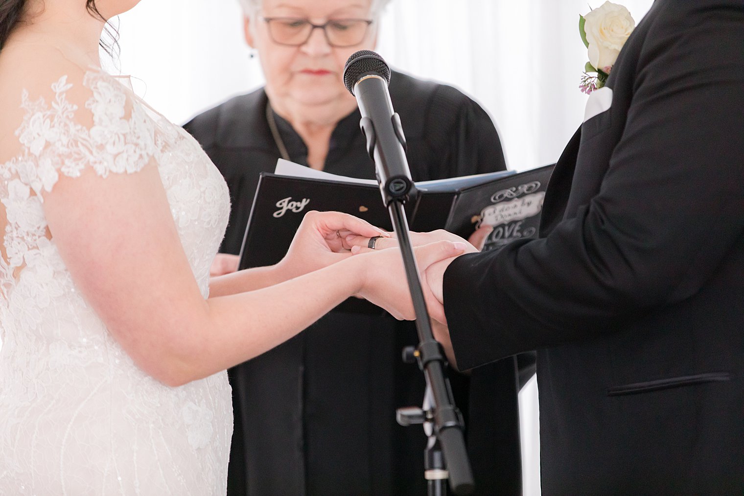 bride puts groom's ring on his hand during wedding ceremony 