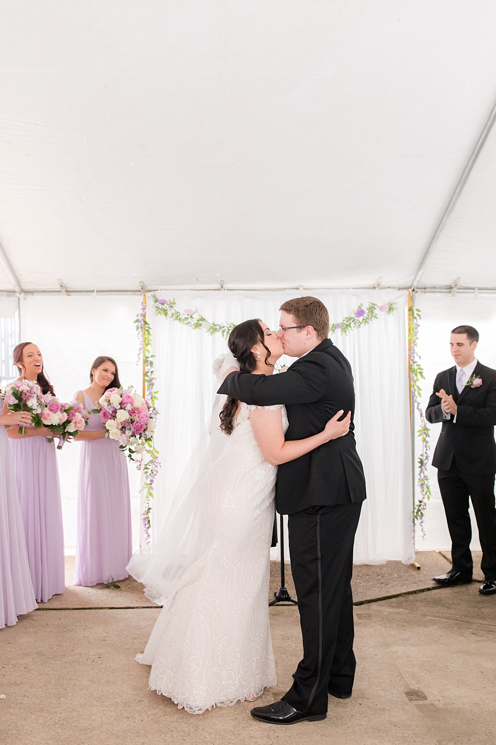 newlyweds kiss during backyard wedding ceremony 