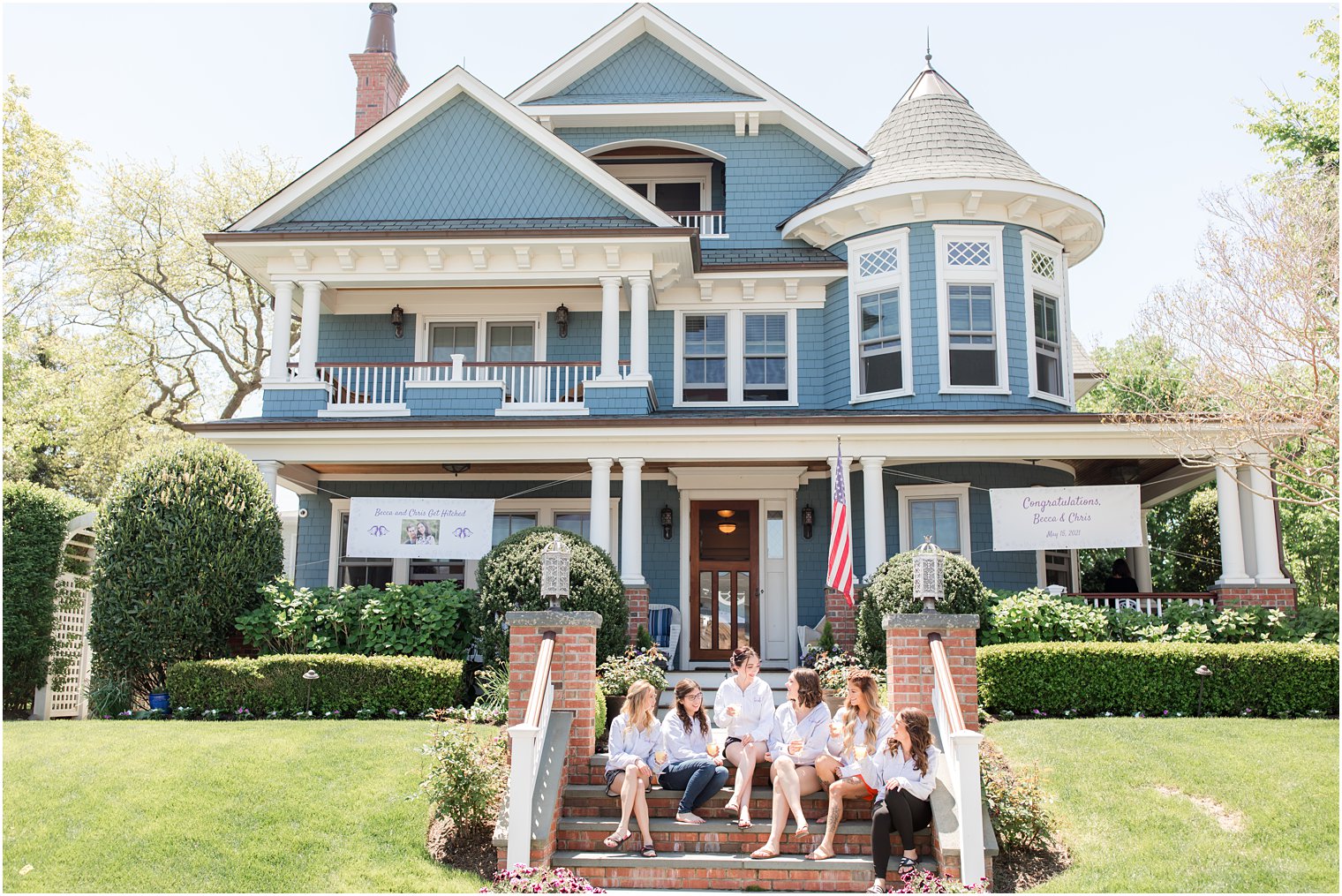 bride sits with bridesmaids on steps outside NJ home