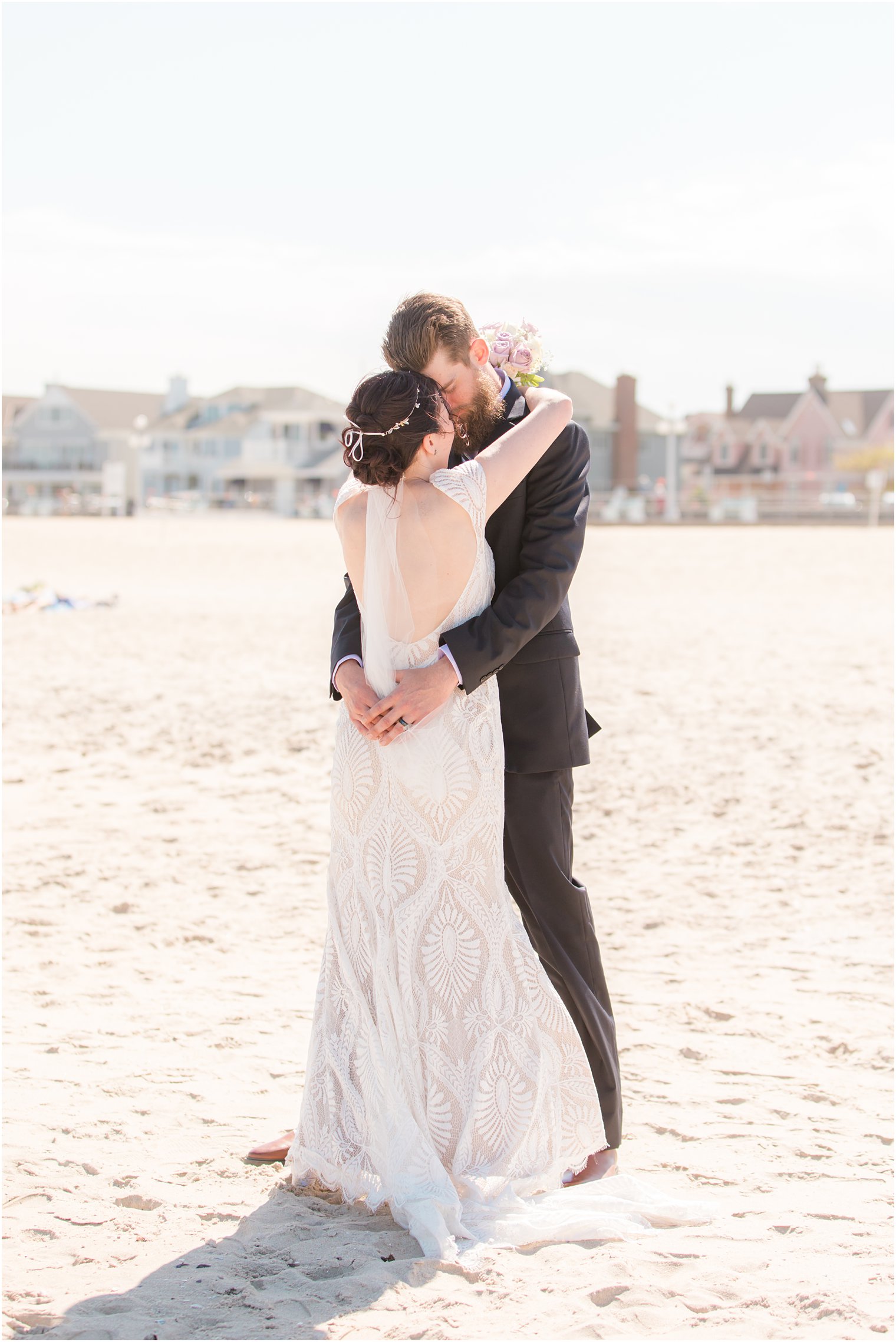 bride and groom hug on sand during NJ wedding portraits 