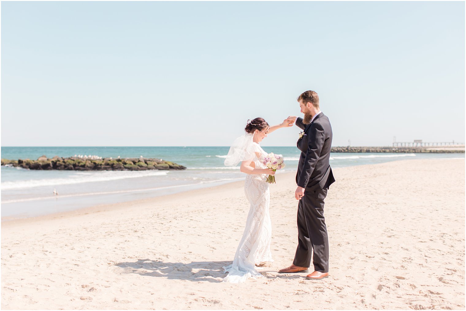 groom twirls bride on beach in New Jersey