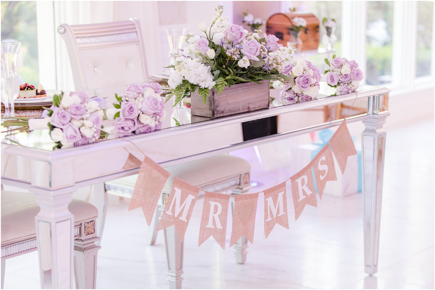 sweetheart table with bouquets of purple flowers