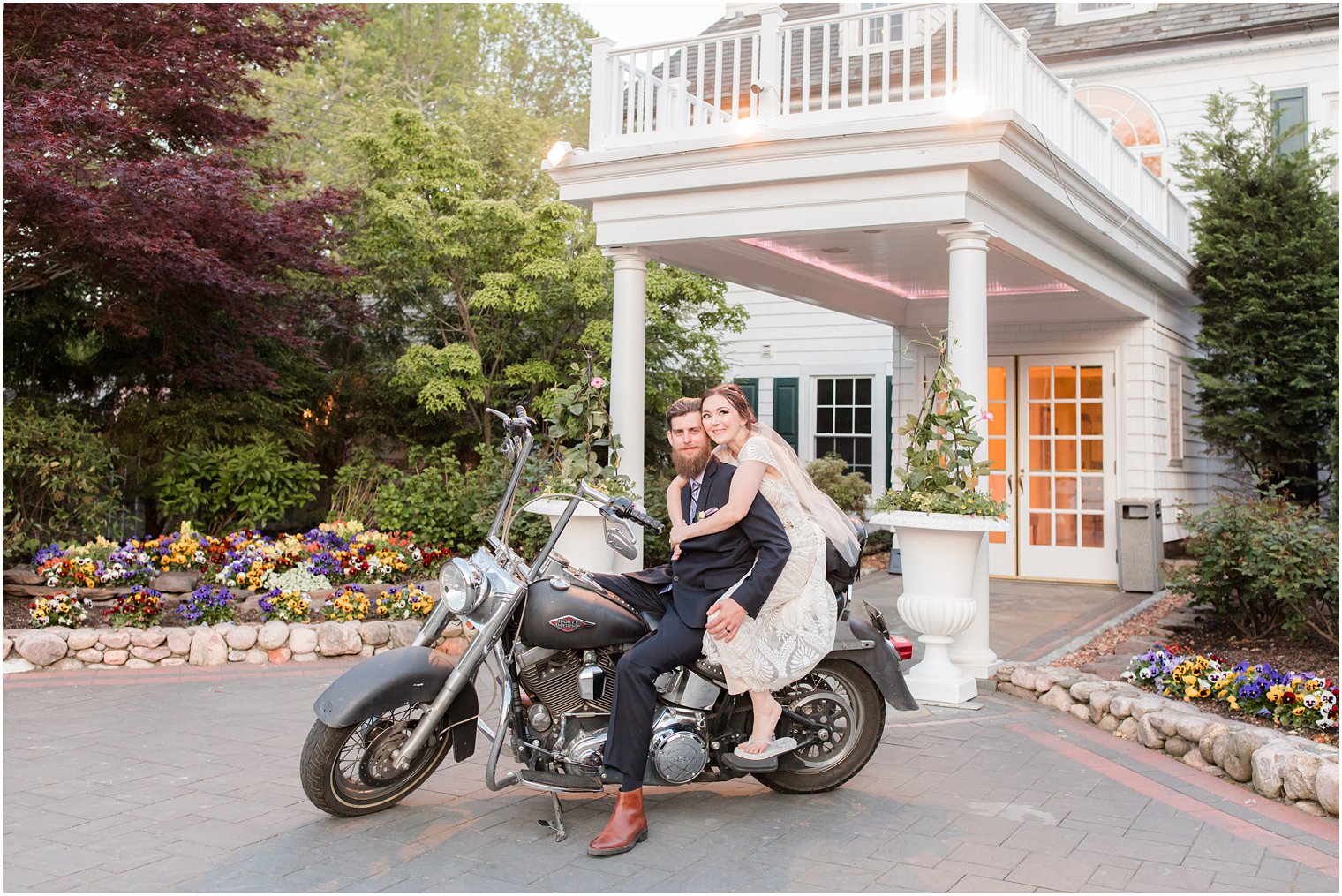 newlyweds pose on motorcycle outside The English Manor