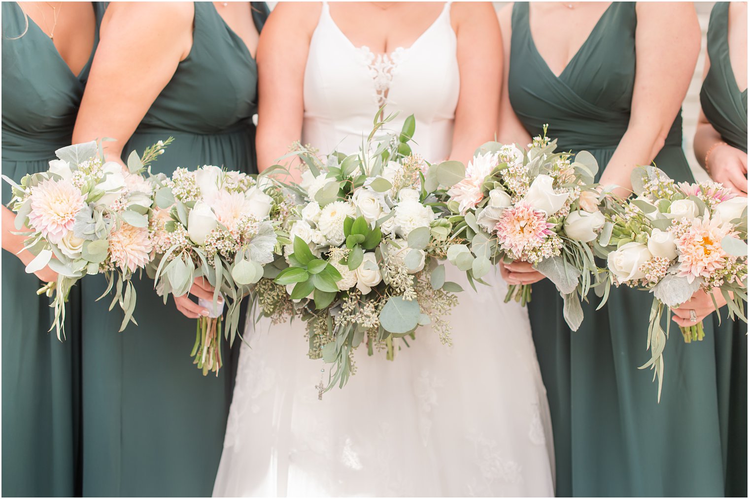 bride and bridesmaids hold bouquet of pink and sage green flowers