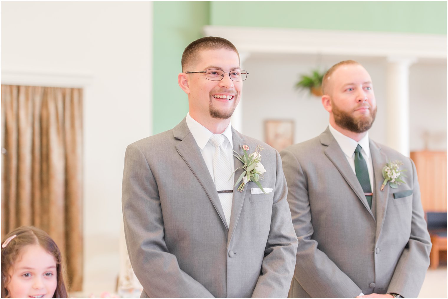 groom smiles at bride walking down aisle during traditional church wedding in New Jersey