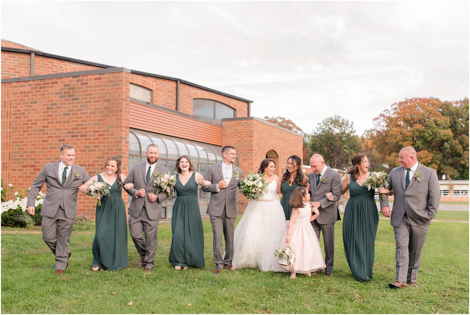 bride and groom walk with bridal party in New Jersey outside church