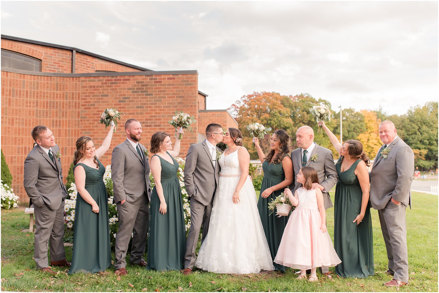 newlyweds kiss while bridal party cheers for them in New Jersey