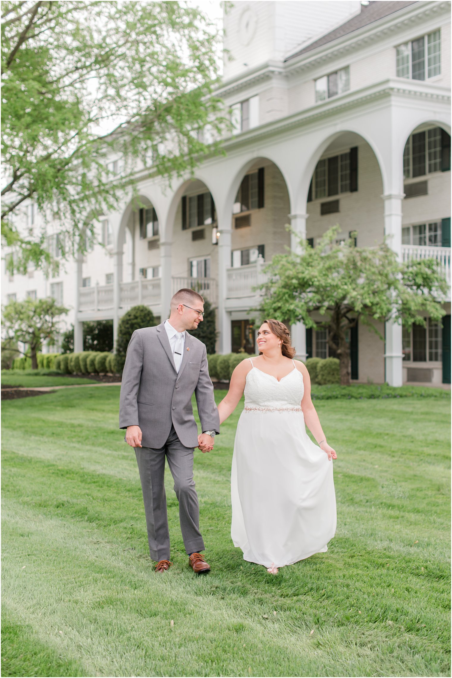 bride and groom walk through lawn at The Madison Hotel