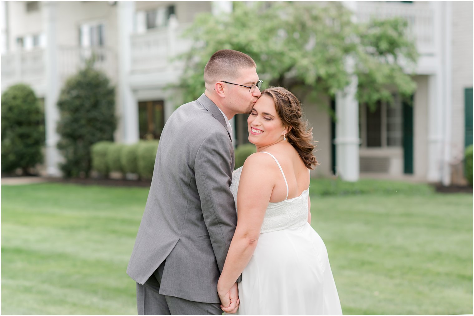 groom kisses bride's forehead during The Madison Hotel wedding portraits
