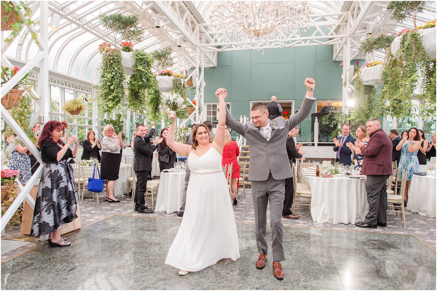 bride and groom cheer while they walk into New Jersey wedding reception