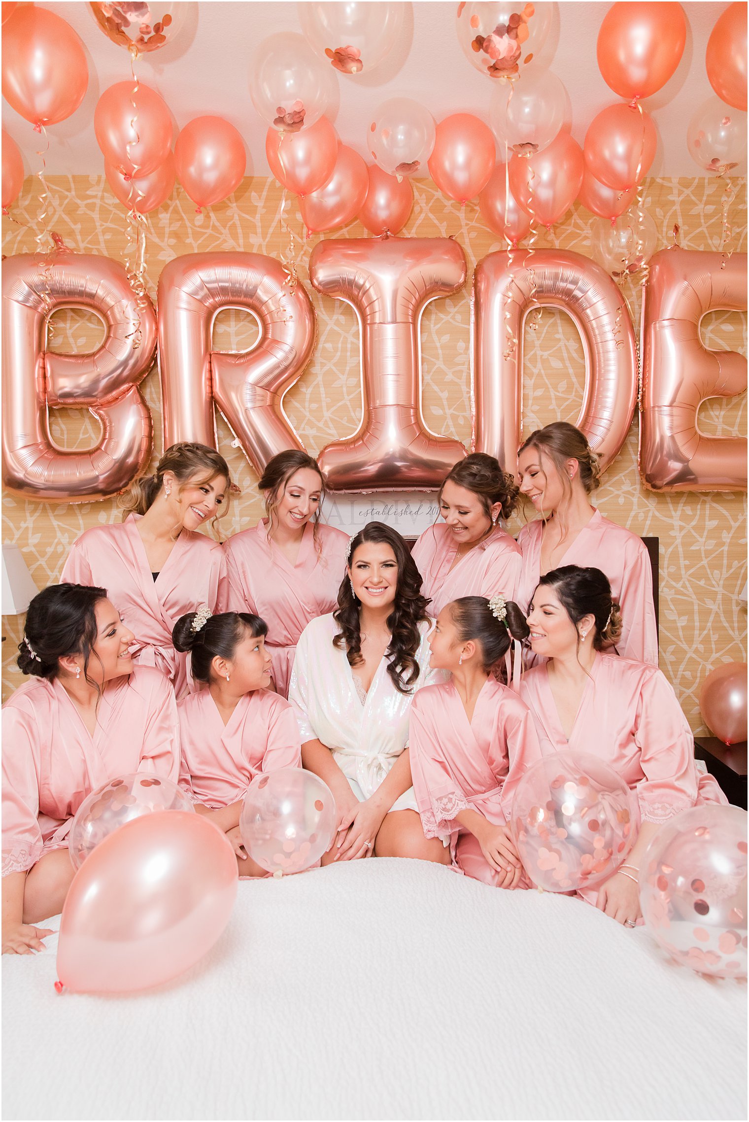 bride smiles with bridesmaids under custom balloons