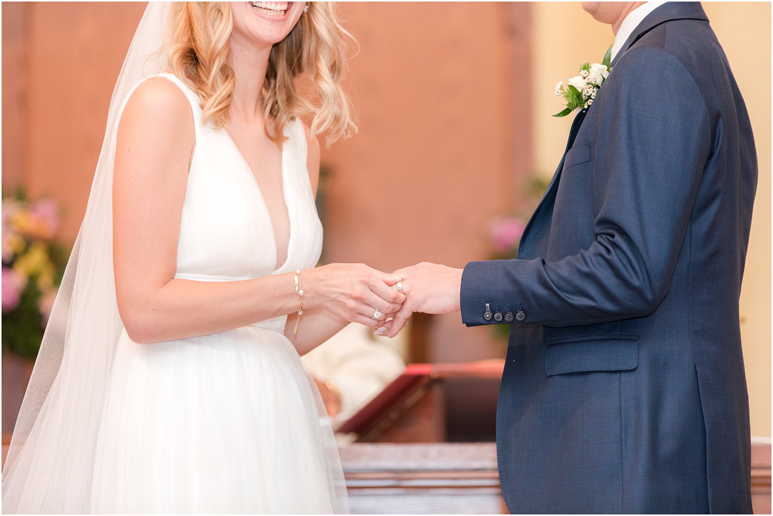 bride and groom laugh while exchanging rings during church wedding in New Jersey 