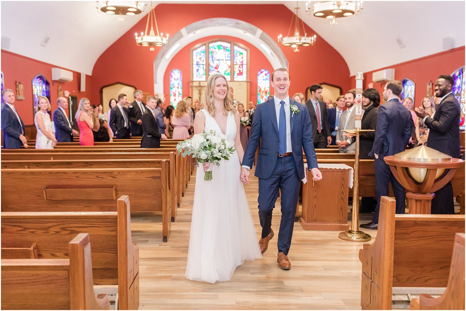 bride and groom walk up aisle in church after NJ wedding ceremony 