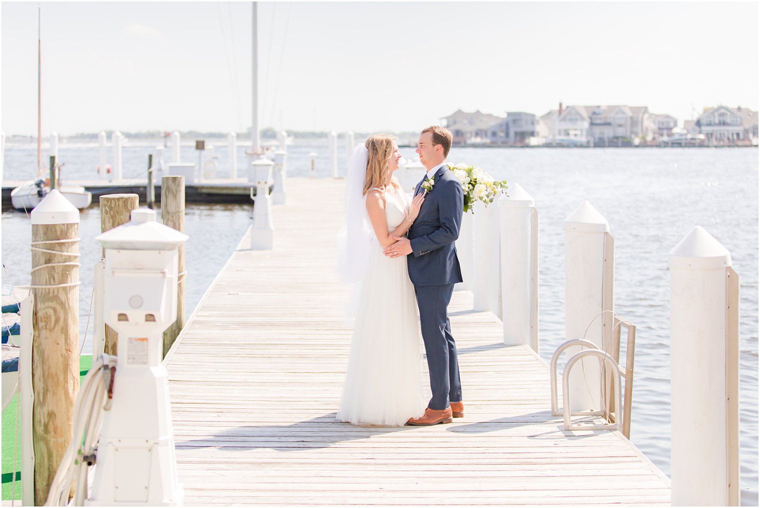 bride and groom stand together on dock at Bay Head Yacht Club