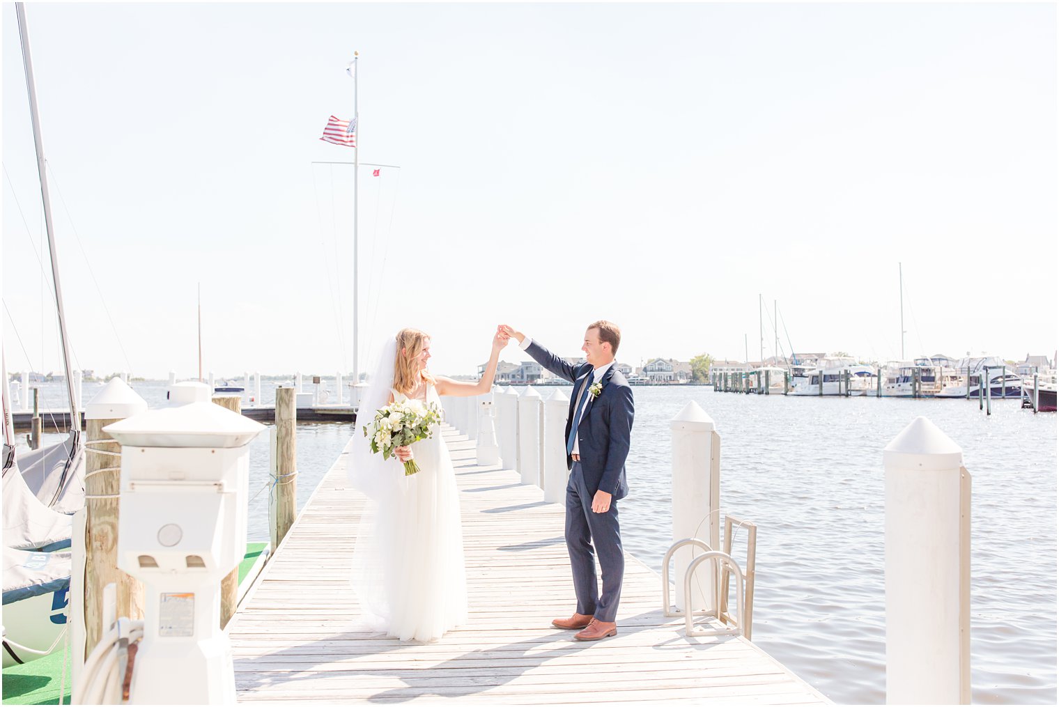 groom twirls bride on dock during wedding photos in Bay Head 