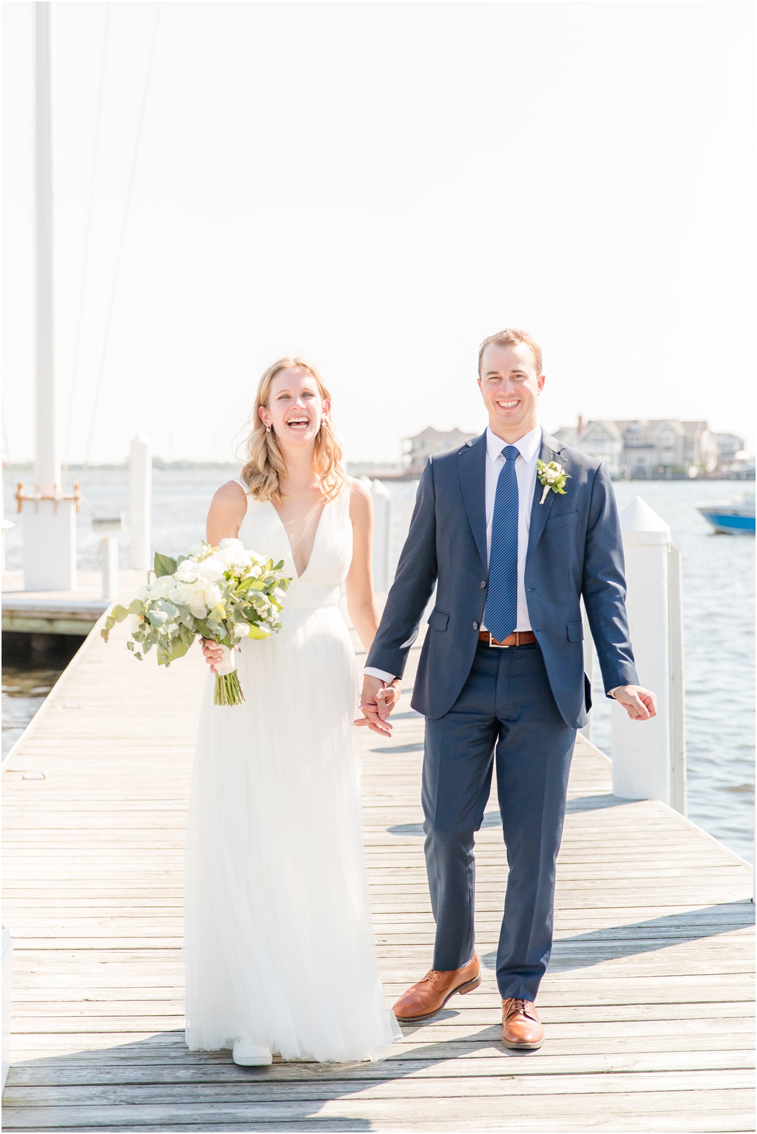 bride and groom walk on pier at Bay Head Yacht Club