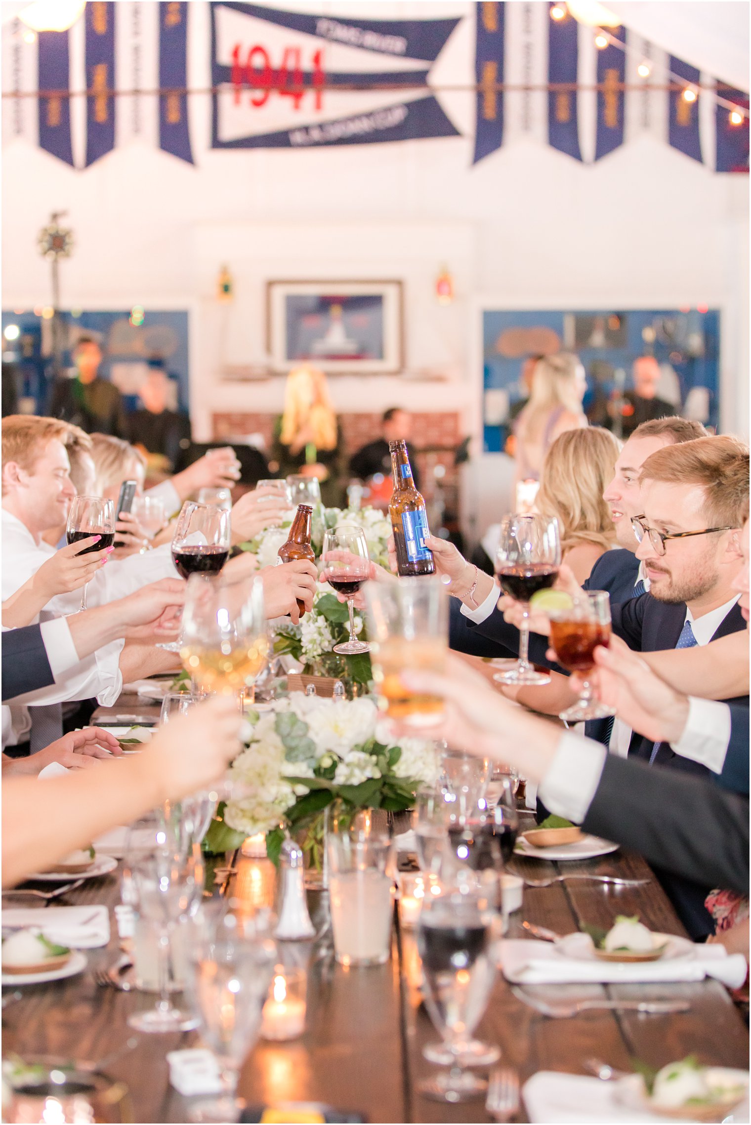 wedding guests toast down family style table at Bay Head Yacht Club wedding reception 