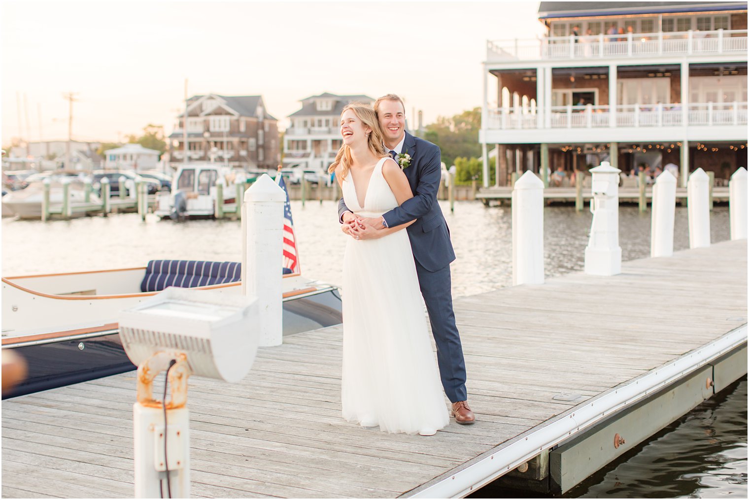 groom hugs bride from behind and makes her laugh during NJ wedding day 