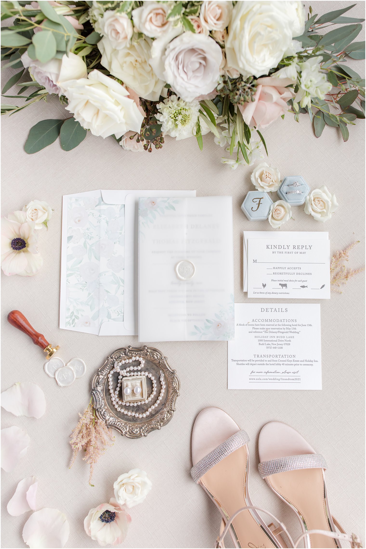flatlay of wedding invitation, bouquet, shoes, and jewelry in soft pastel colors