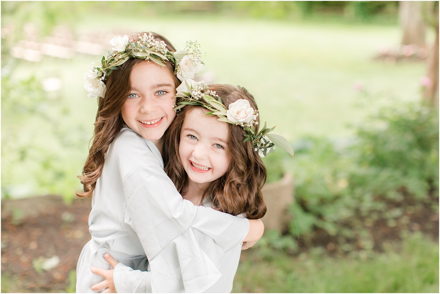 two flower girls with flower crowns hugging each other at Crossed Keys Estate wedding