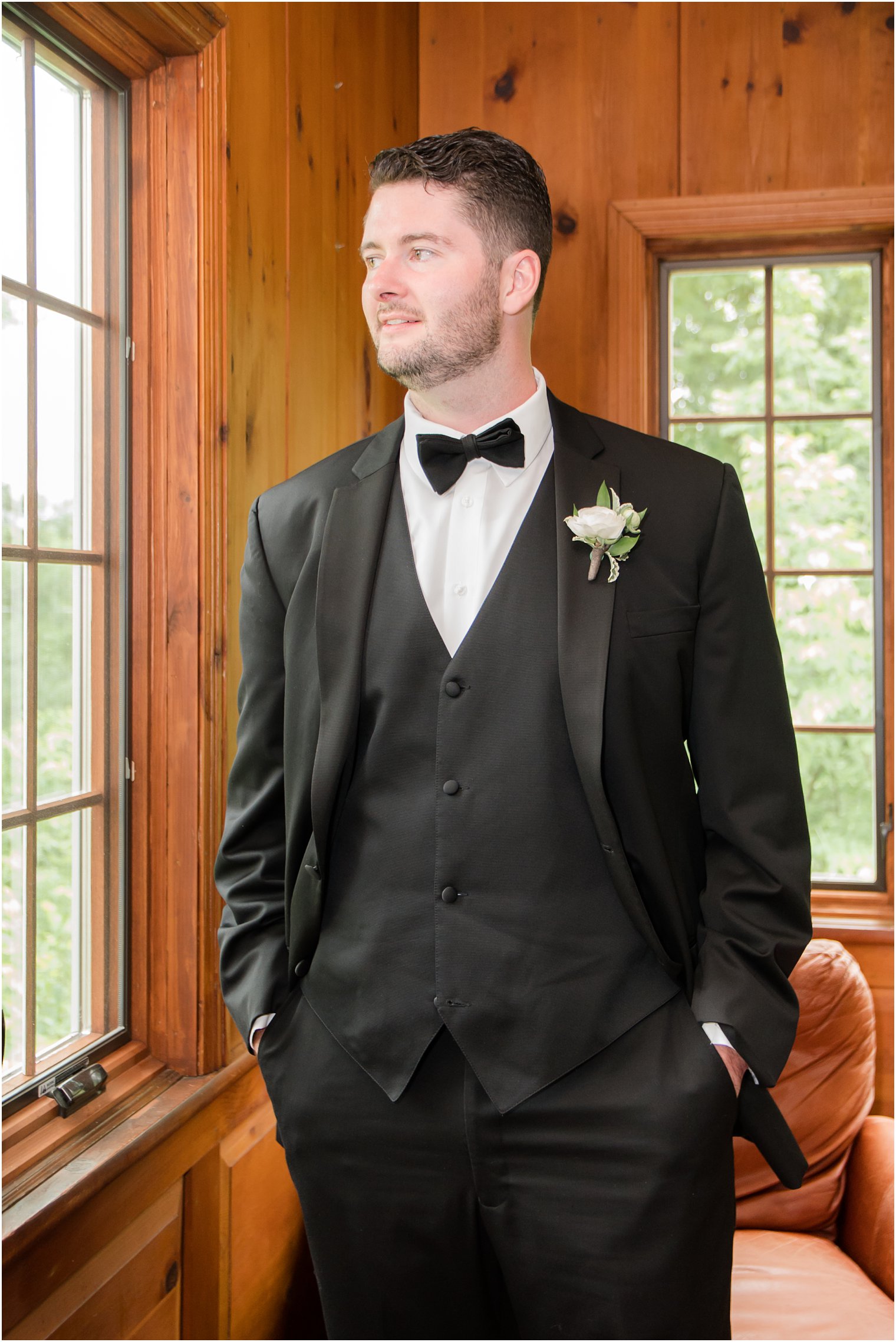 elegant groom portrait by a window