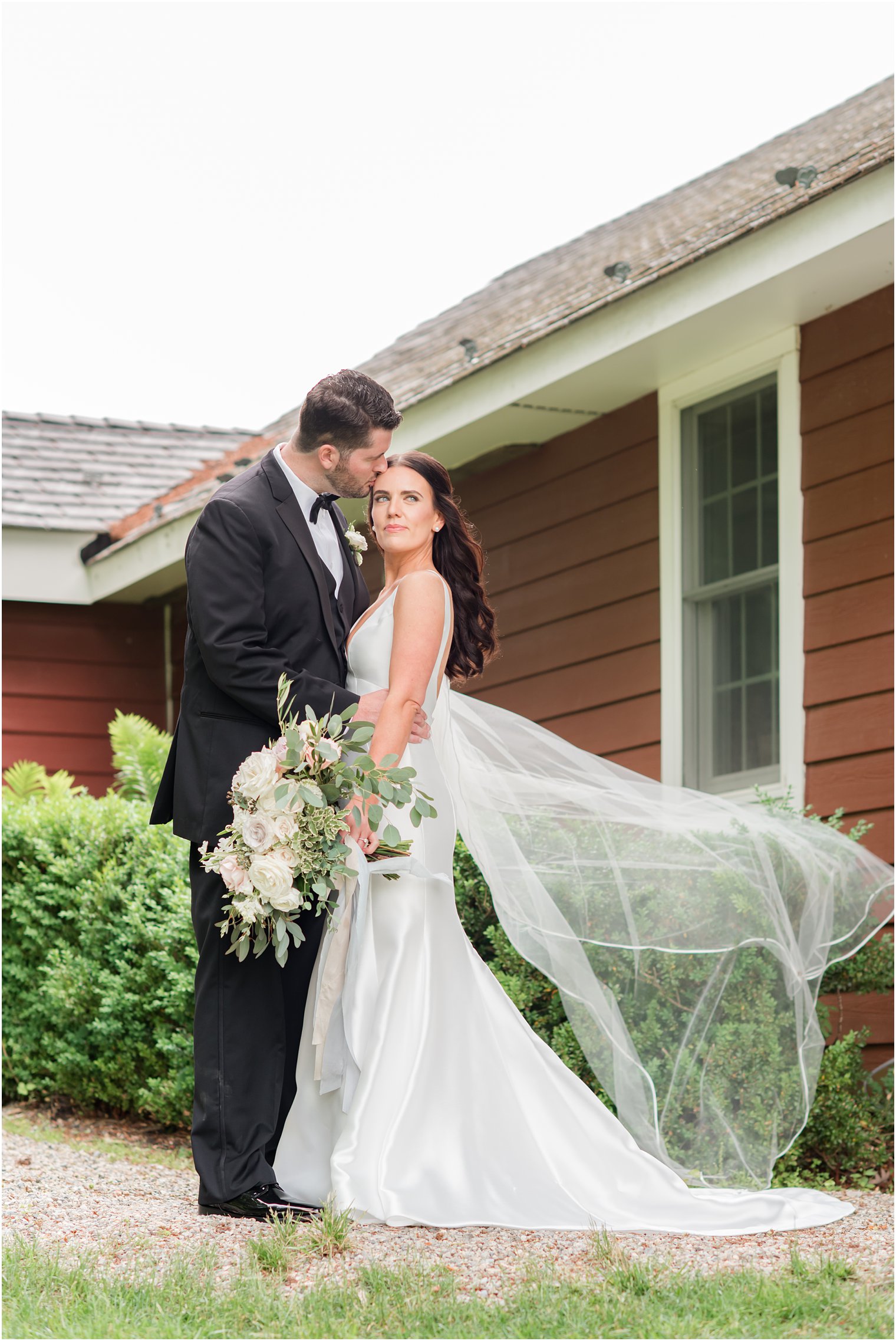 bride and groom photo with veil blowing in the wind at Crossed Keys Estate