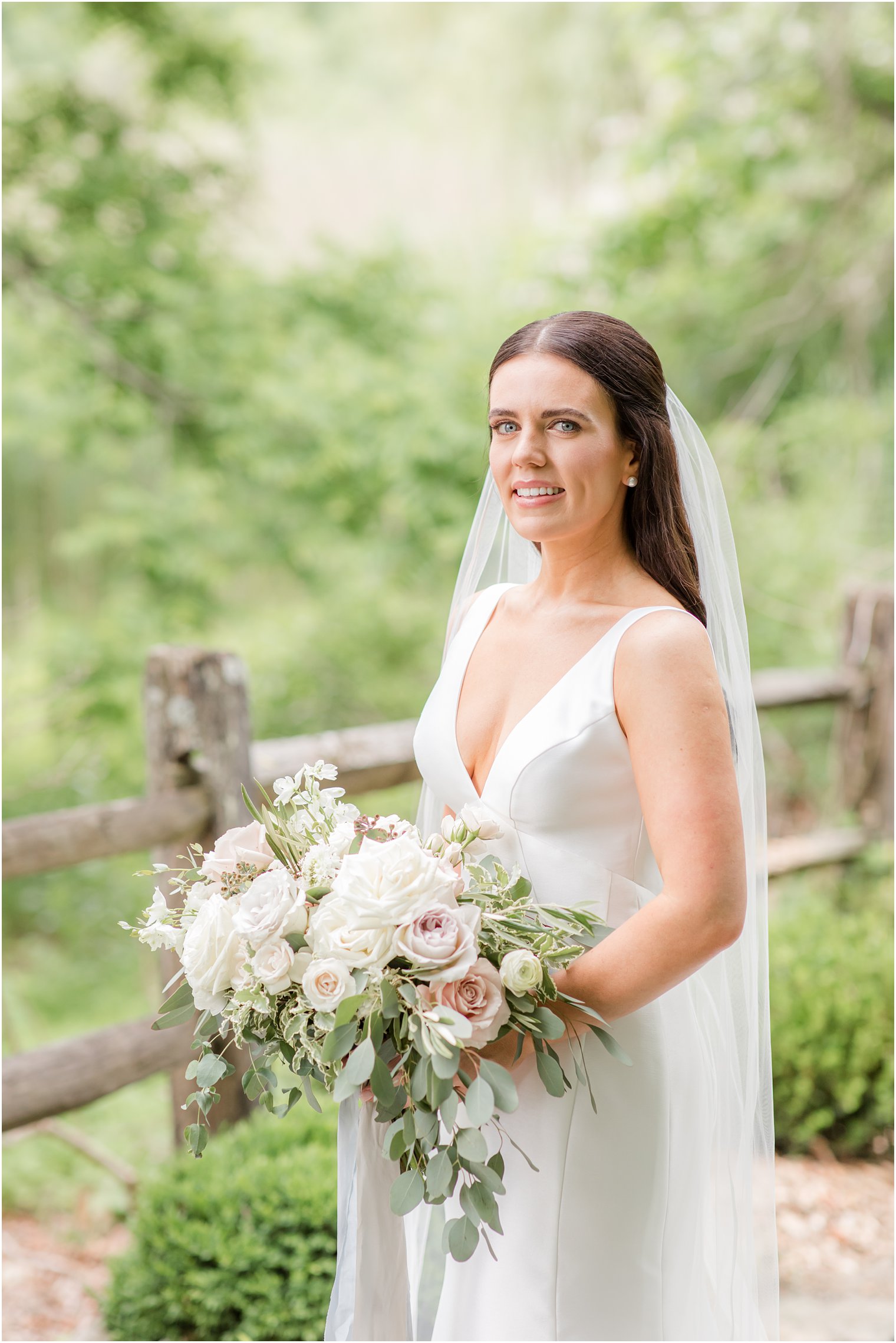 Bridal portrait of elegant bride in simple white dress with cathedral veil