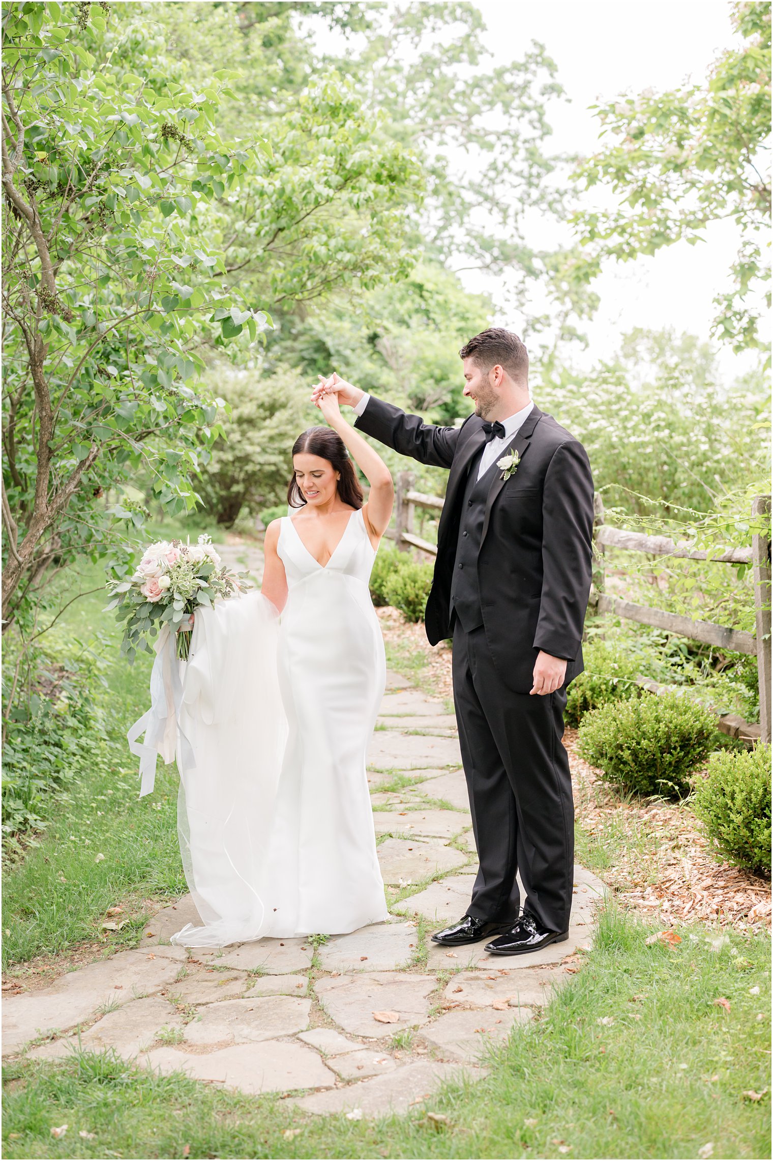 groom twirling his bride in wedding attire