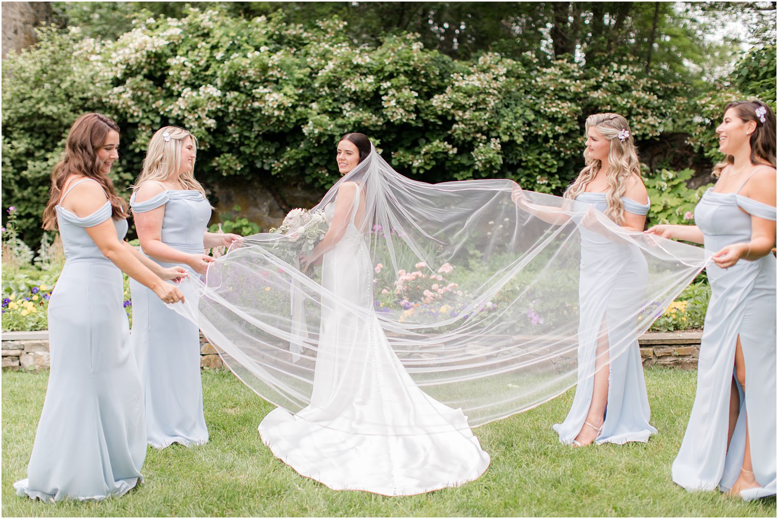 bridesmaids helping bride with her cathedral veil