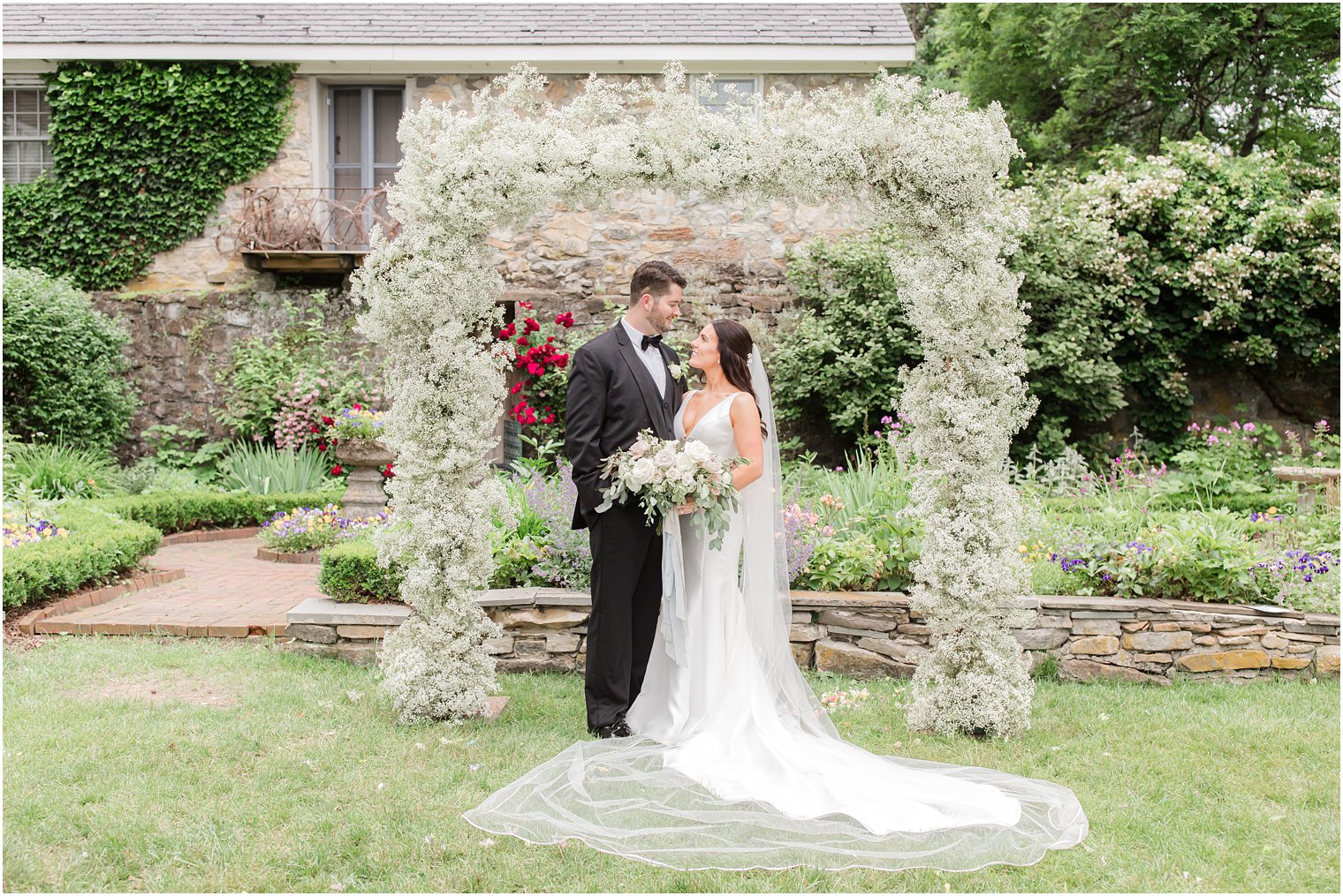elegant portrait of bride and groom at Crossed Keys Estate under floral arbor