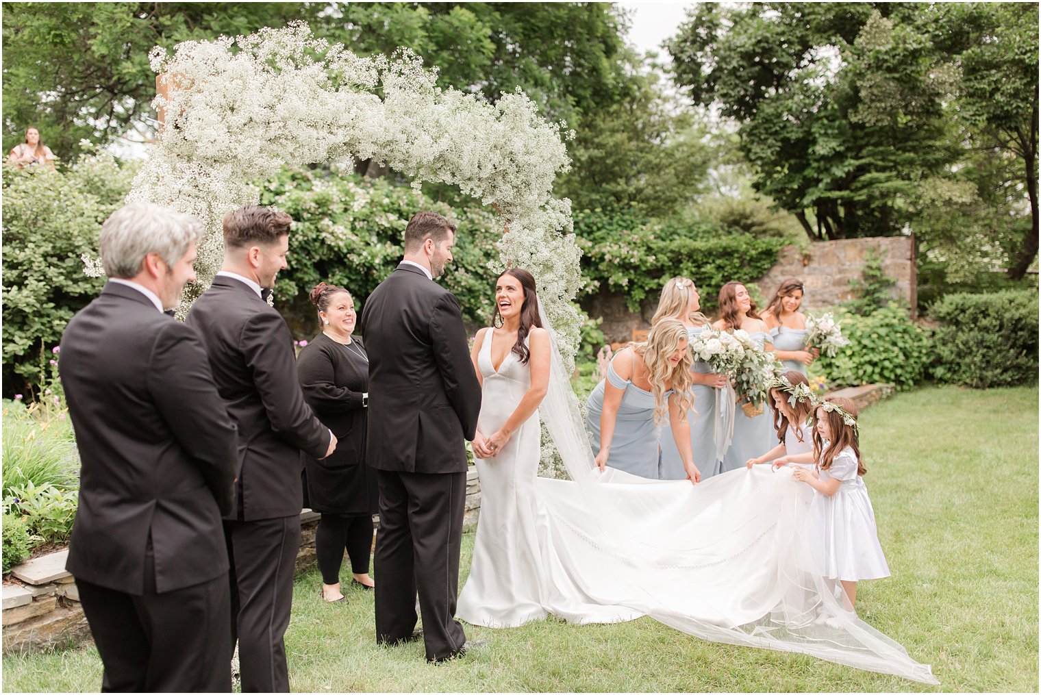 flower girls helping bride with dress during ceremony