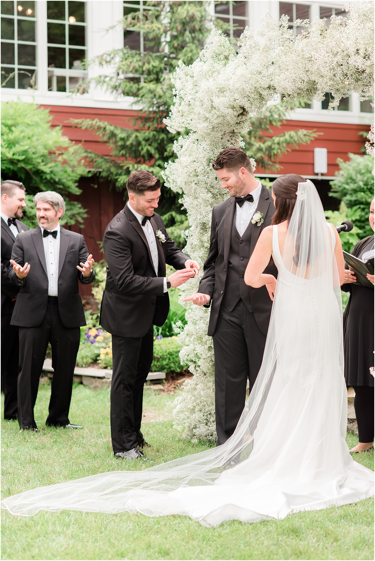 best man giving groom the wedding bands during ceremony