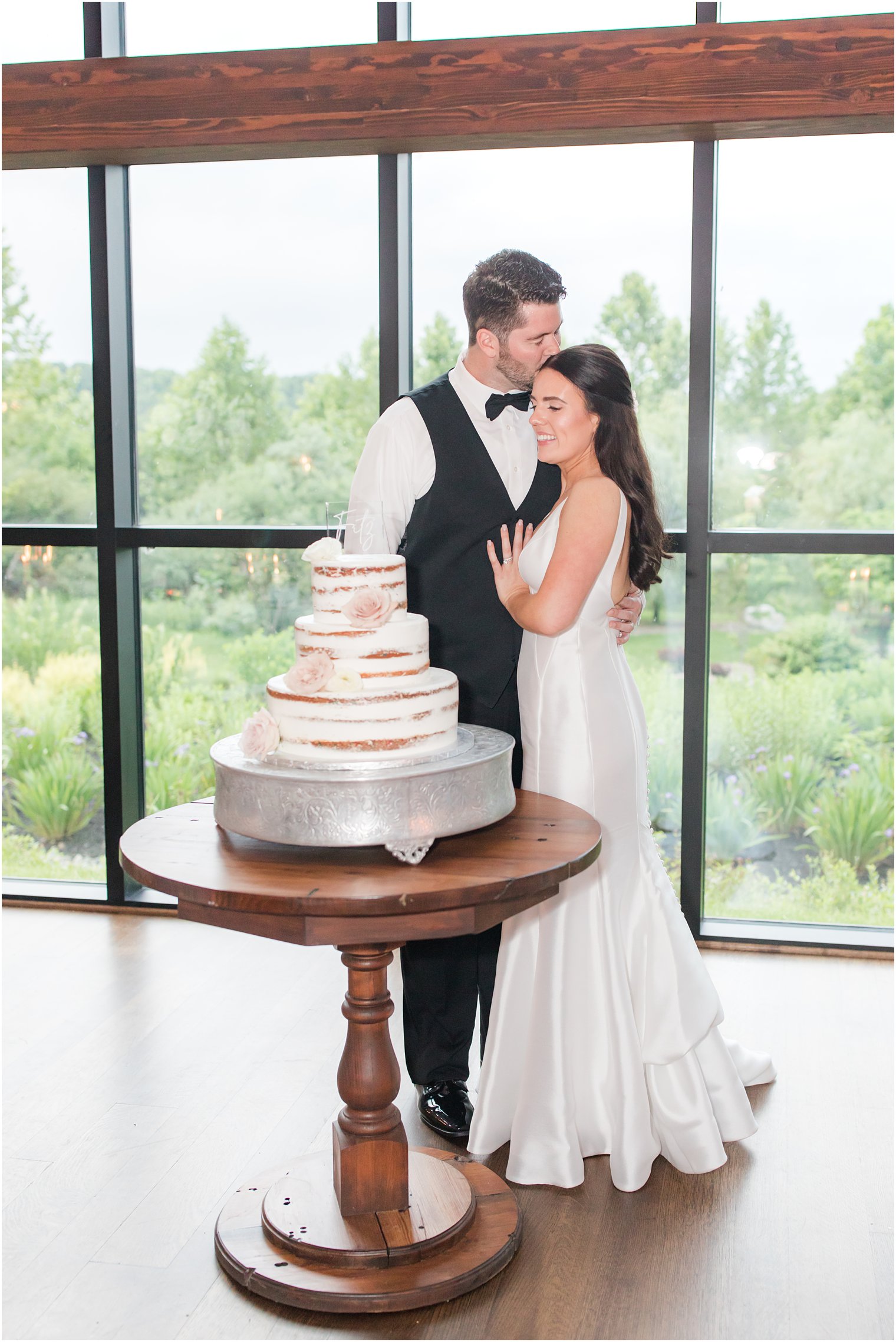 groom kissing bride at cake cutting