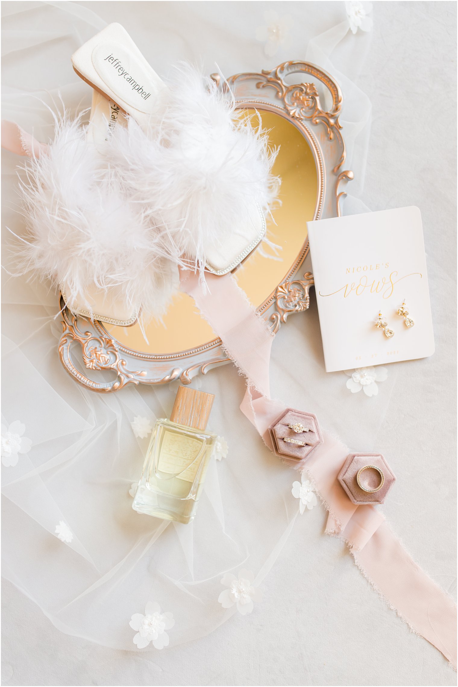 bride's jewelry and slippers with fluff sit on gold tray 