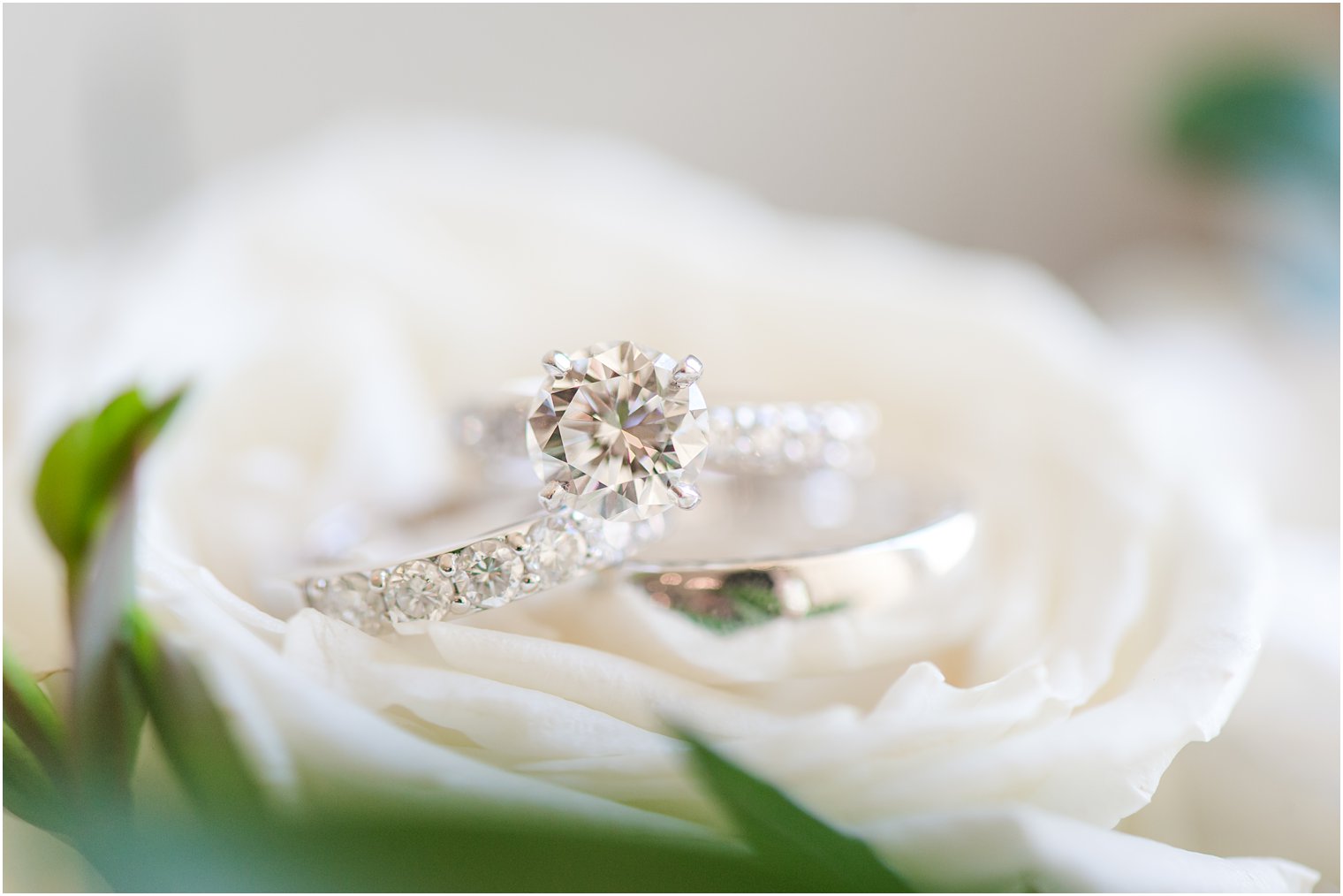 diamond ring rests on white rose before NJ wedding 