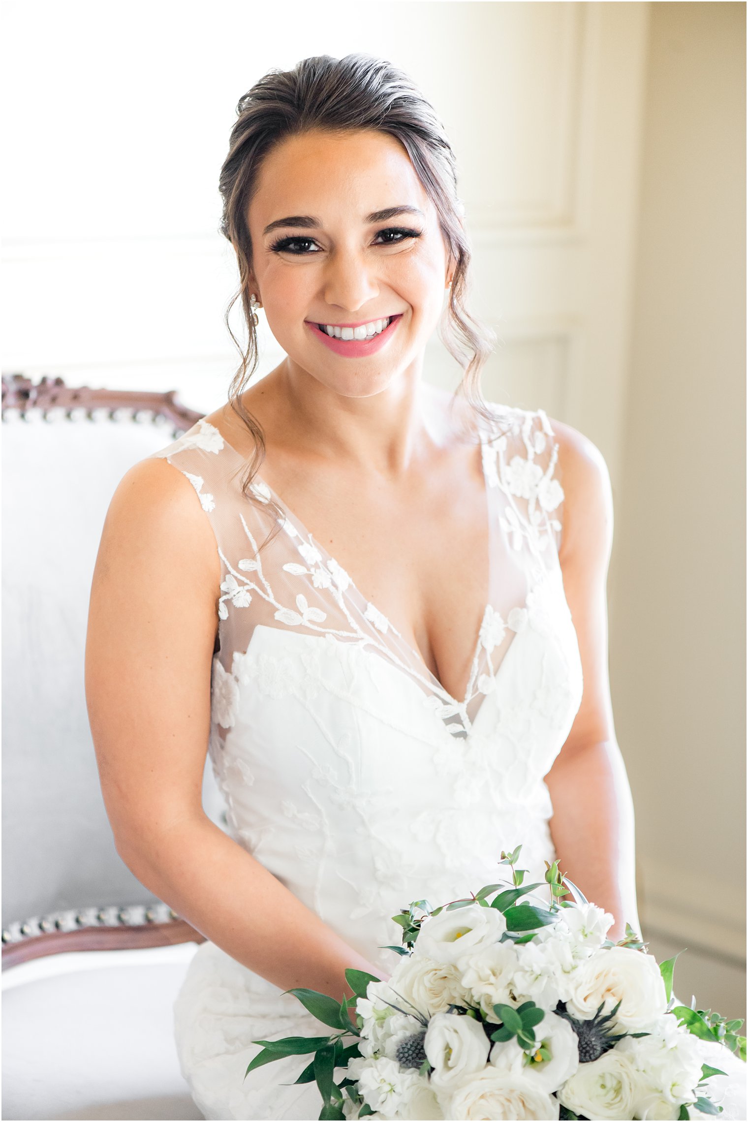 bride sits holding bouquet in wedding gown with lace over lay at Park Savoy Estate