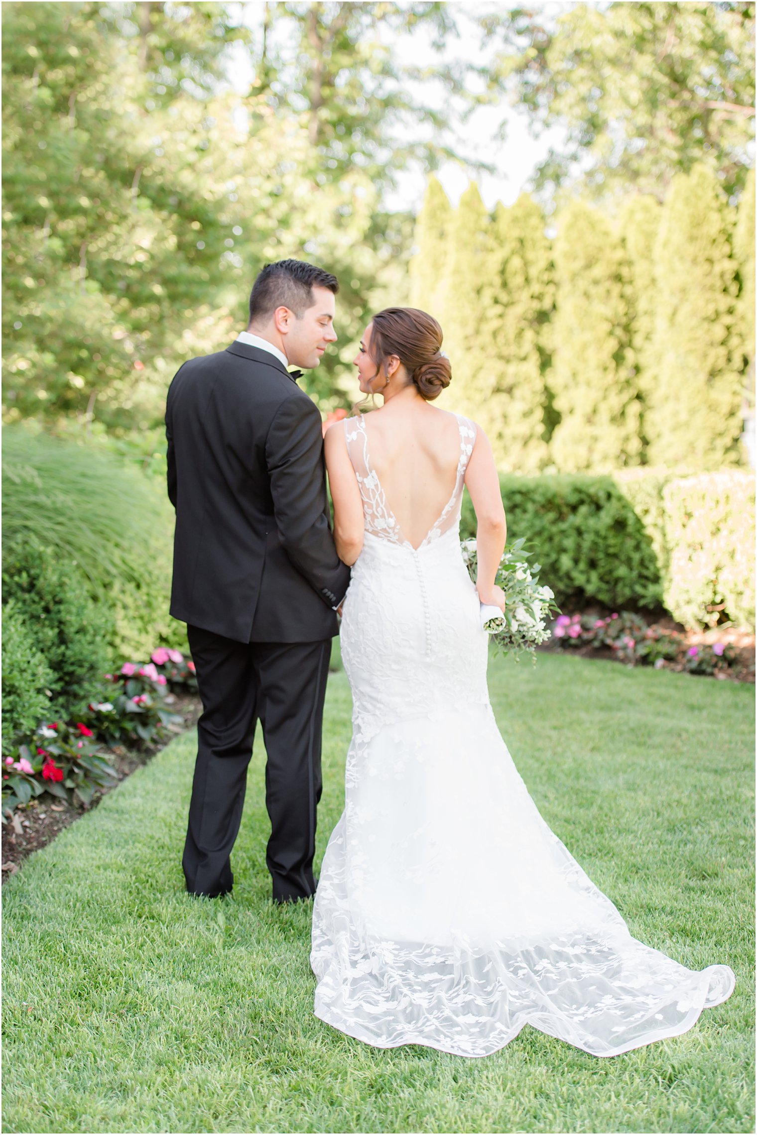 bride and groom walk through garden at NJ wedding venue 