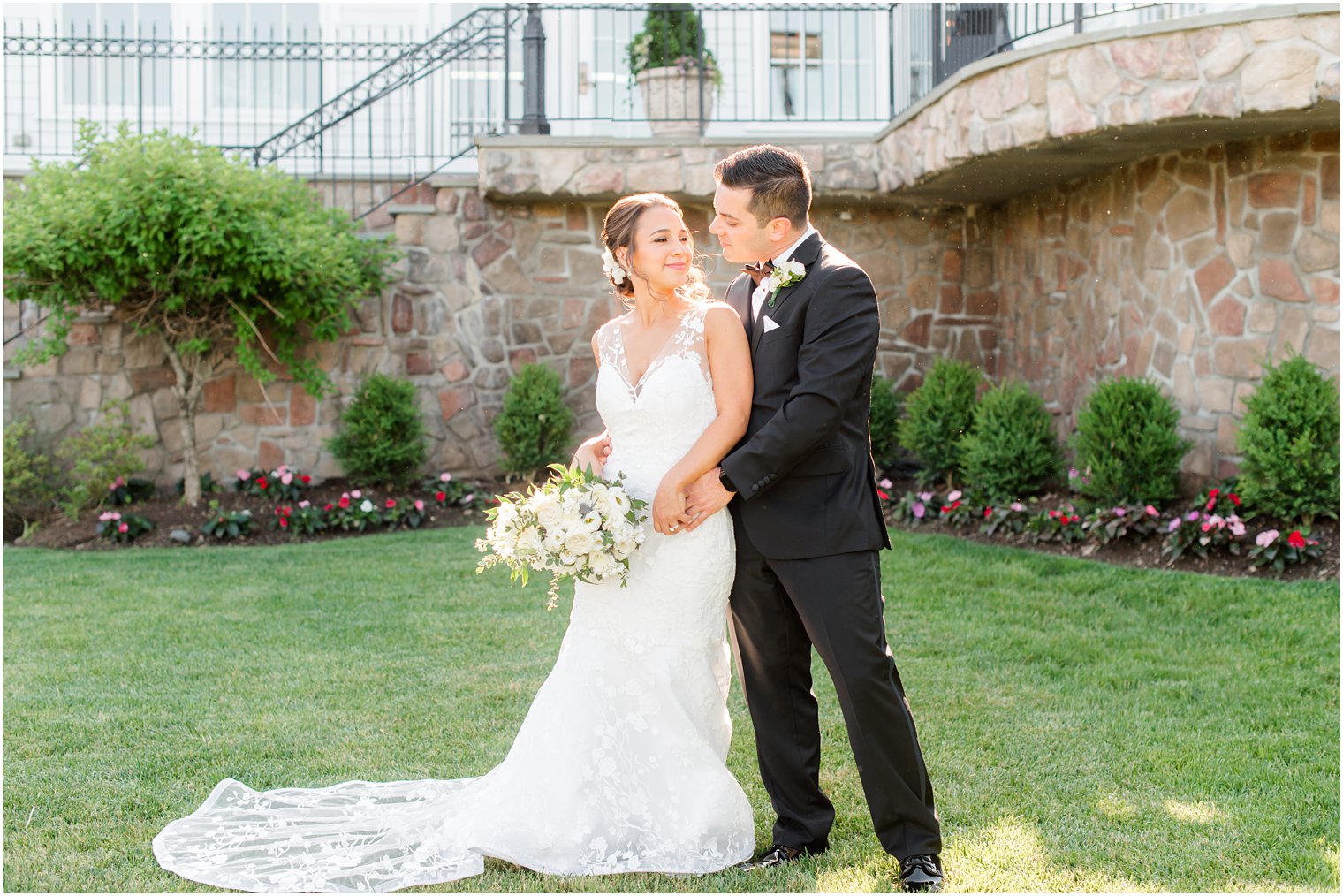 groom holds bride's hip during NJ wedding photos at Park Savoy Estate