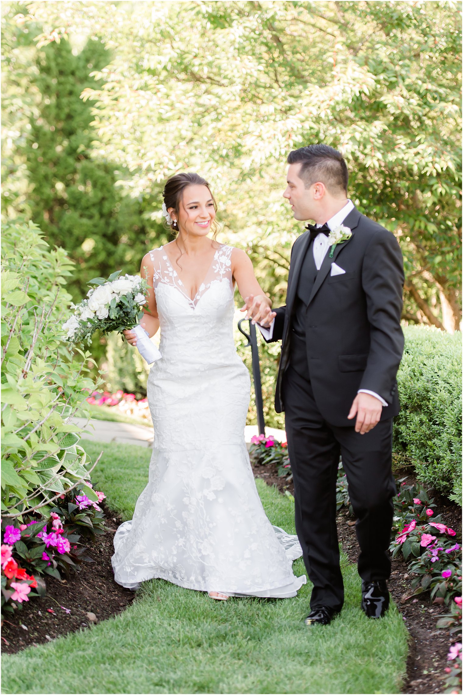 bride and groom hold hands walking through gardens in New Jersey 