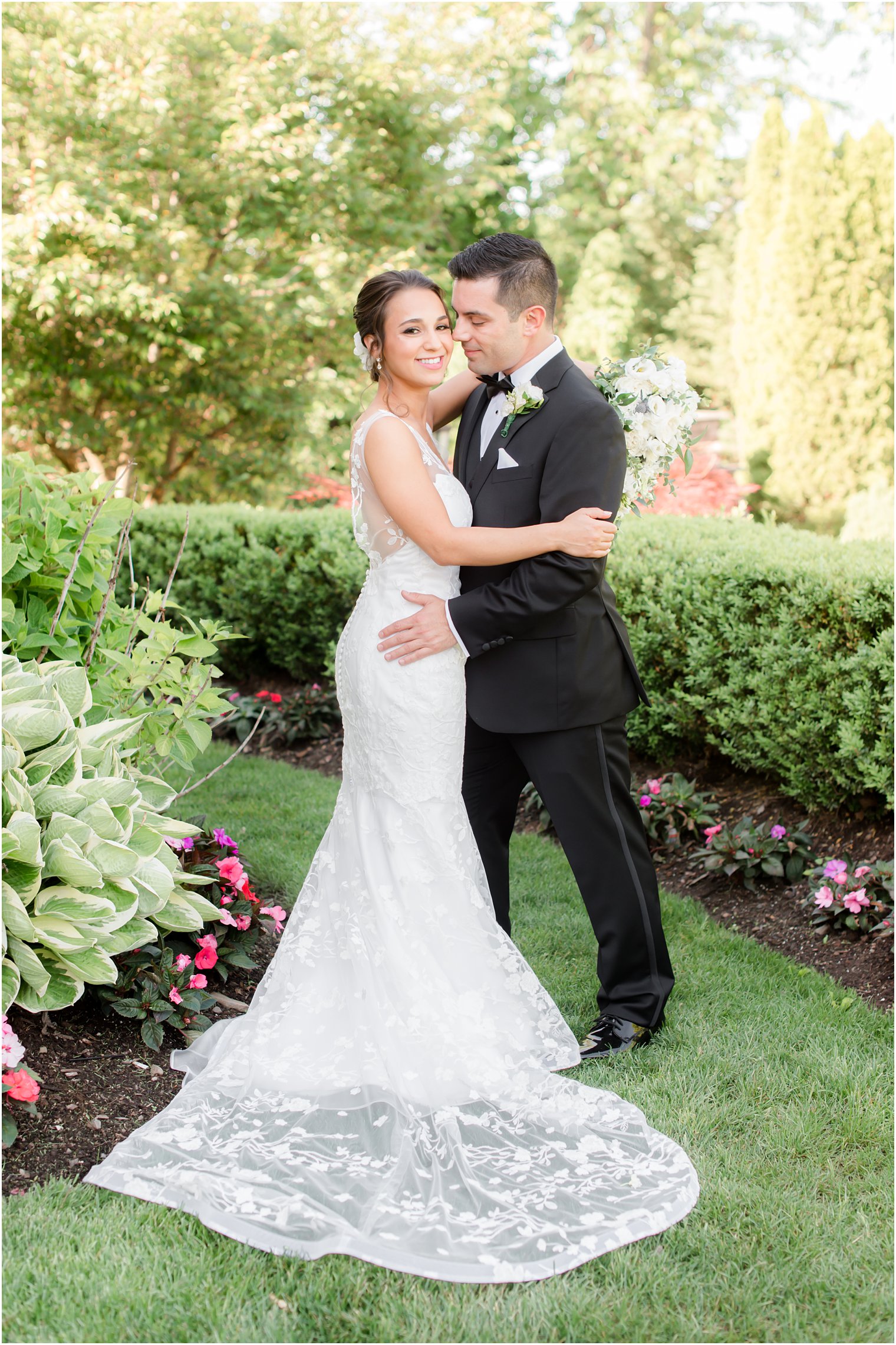 bride and groom hug in gardens of New Jersey wedding venue 