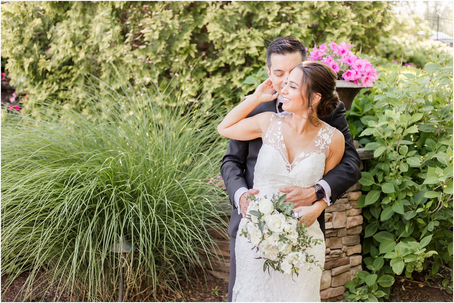 bride reaches for groom while he holds her waist in gardens of Park Savoy Estate