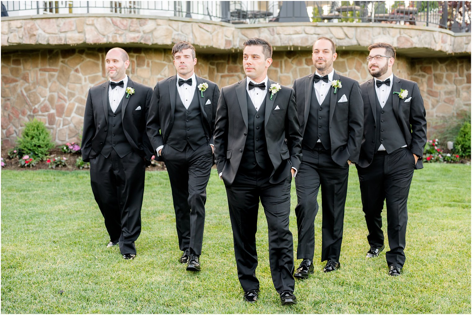 groom walks with groomsmen in classic black tuxes 