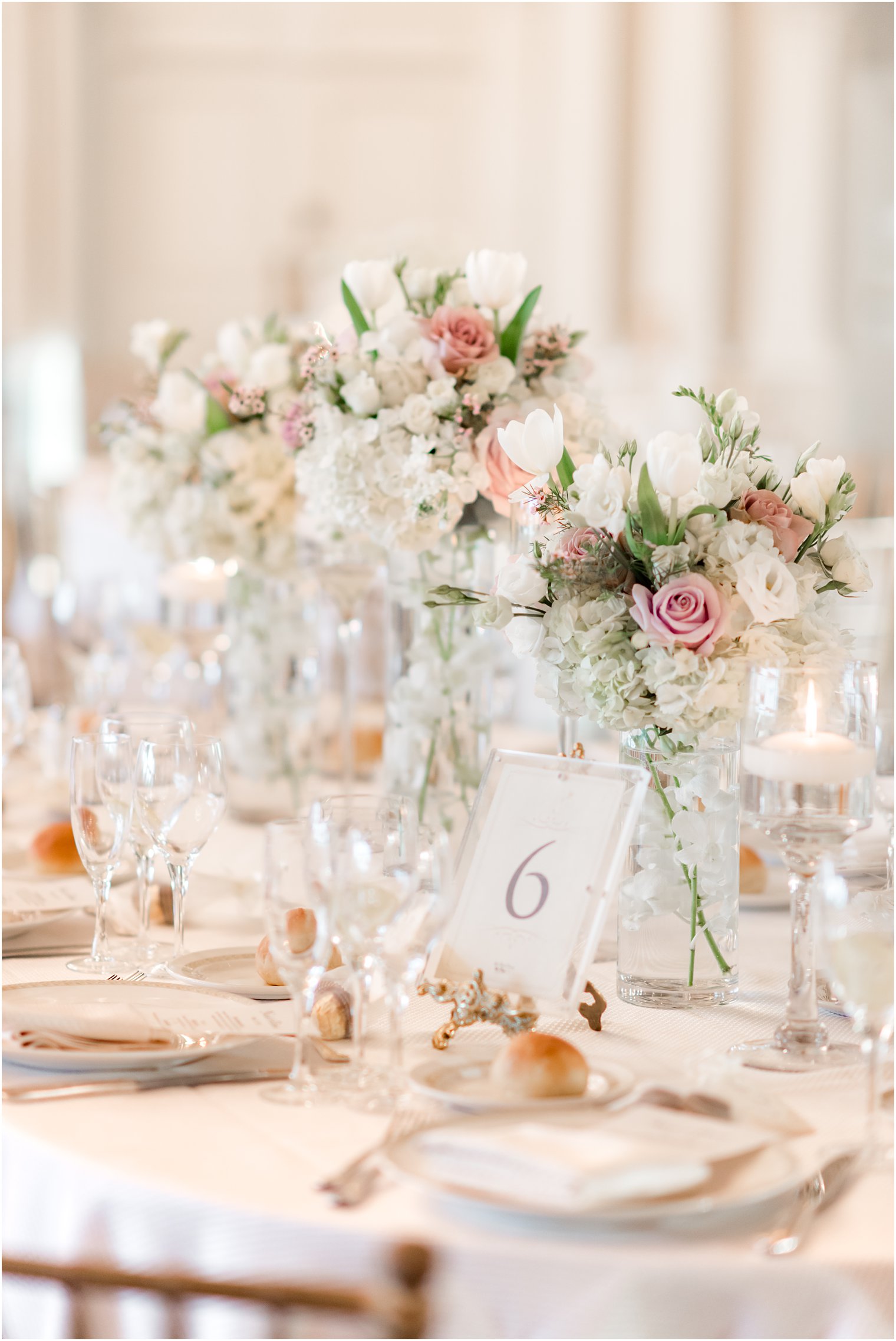 table numbers and bouquets on reception table with pale pink and white roses 