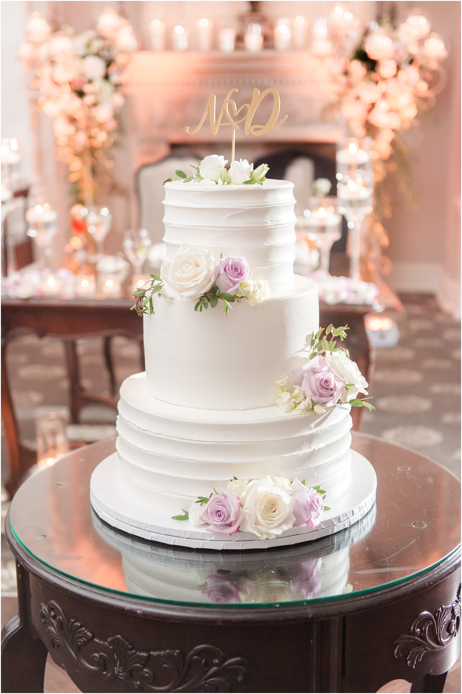tiered wedding cake with purple and ivory roses 
