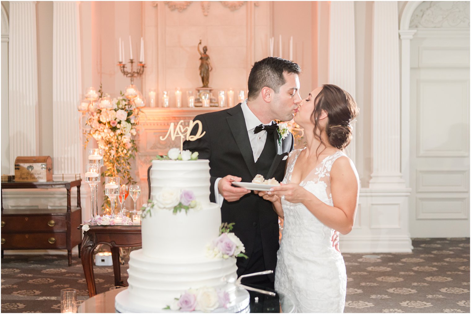 bride and groom kiss by tiered wedding cake at Park Savoy Estate