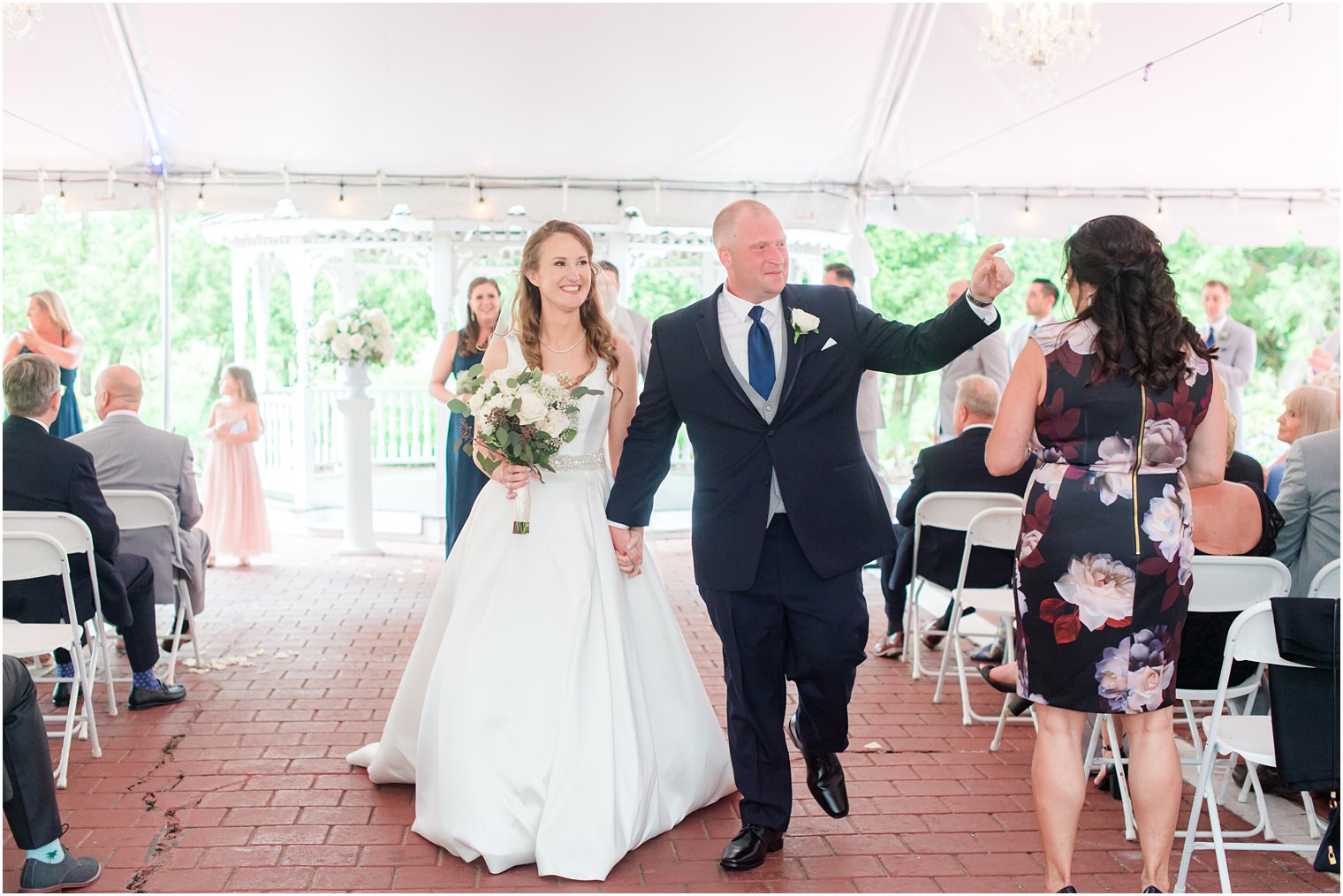 newlyweds leave wedding ceremony talking to guests 